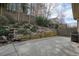 Fenced backyard with landscaping, stone retaining wall, and a grill at 620 Willow Haven Way, Suwanee, GA 30024