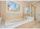 Bathroom featuring a bathtub, glass shower, and a large window that offers plenty of natural light at 620 Willow Haven Way, Suwanee, GA 30024