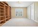 Bedroom showcasing built-in bookshelves, neutral carpet, and a bright window at 620 Willow Haven Way, Suwanee, GA 30024