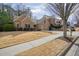 Lovely brick home with a two-car garage, a spacious driveway, and mature trees surrounding the property at 620 Willow Haven Way, Suwanee, GA 30024