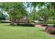 Beautifully landscaped community area with manicured lawn, mature trees, and a charming fountain at 1075 Lancaster Sq, Roswell, GA 30076