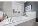 Relaxing bathtub with tile surround, and a window letting in natural light at 3111 Old Thompson Mill Rd, Buford, GA 30519