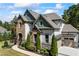 Stylish two-story home with lush landscaping around the home and a two car garage on the side at 3111 Old Thompson Mill Rd, Buford, GA 30519