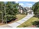 Beautifully situated two-story home with a long paved driveway, attached two-car garage, and mature trees at 3111 Old Thompson Mill Rd, Buford, GA 30519
