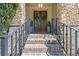 Brick stairway leads to a double door with a stone archway, enhanced with wrought iron railing at 3111 Old Thompson Mill Rd, Buford, GA 30519