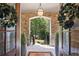 Exterior stone archway and light fixture over a front entrance with double doors and stone flooring at 3111 Old Thompson Mill Rd, Buford, GA 30519