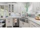 Bright kitchen features white cabinets, granite countertops, stainless steel sink, and tiled backsplash at 3111 Old Thompson Mill Rd, Buford, GA 30519