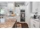 Gourmet kitchen boasts stainless steel appliances, granite countertops, white cabinets, and modern fixtures at 3111 Old Thompson Mill Rd, Buford, GA 30519