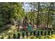 Backyard wooden playground featuring a slide, swings, and climbing features, perfect for Gathering fun at 3111 Old Thompson Mill Rd, Buford, GA 30519