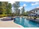 Inviting backyard pool and spa area with ample seating and lush landscaping at 3111 Old Thompson Mill Rd, Buford, GA 30519