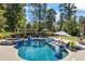 Beautiful backyard pool featuring a spa, water slide, and comfortable lounge areas at 3111 Old Thompson Mill Rd, Buford, GA 30519