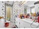 Bathroom featuring floral wallpaper, a pedestal sink, and an adjoining room with a toilet at 3434 Saddlebrook Dr, Loganville, GA 30052