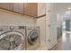 Bright laundry room featuring front-load washer and dryer, cabinets, and convenient hanging hooks at 222 Inman Ne Ln, Atlanta, GA 30307