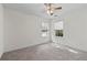 Empty bedroom featuring plush carpet, ceiling fan, and natural light from two windows at 3716 Vineyards Lake Nw Cir # U-2, Kennesaw, GA 30144