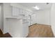 Efficient kitchen layout featuring white cabinets, appliances, and wood-look flooring at 3716 Vineyards Lake Nw Cir # U-2, Kennesaw, GA 30144