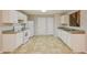 This kitchen features white cabinets, linoleum floors and white appliances at 6595 Browns Mill Ferry Dr, Lithonia, GA 30038