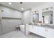 Modern bathroom featuring a freestanding tub, tiled walls, and a double vanity with sleek mirrors at 1273 Danner Se St, Atlanta, GA 30316