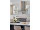 Close-up of kitchen island featuring a stainless steel cooktop, custom vent hood, and marble countertops at 1273 Danner Se St, Atlanta, GA 30316