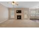 Carpeted living room featuring a fireplace, large TV, ceiling fan, and access to the back yard at 923 Port West Dr, Auburn, GA 30011