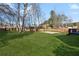 Spacious backyard with lush green lawn, mature trees, privacy fence, and basketball court at 3185 Perch Sw Dr, Marietta, GA 30008