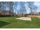 Large, well-maintained backyard featuring a basketball court, surrounded by mature trees and a fence at 3185 Perch Sw Dr, Marietta, GA 30008
