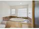 Spacious bathroom with soaking tub that features marble surround, natural light, and separate shower at 3185 Perch Sw Dr, Marietta, GA 30008