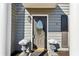 Close-up of the front door, featuring a decorative glass insert, sidelight, and lovely potted plants at 3185 Perch Sw Dr, Marietta, GA 30008