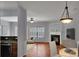 Cozy living room with a fireplace, ceiling fan, and view of the kitchen at 1649 Southgate Mill Dr, Duluth, GA 30096