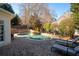 Backyard patio with lounge chairs overlooking pool with waterfall feature surrounded by mature trees at 1850 Kirkmont Nw Dr, Marietta, GA 30064