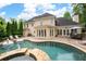 Expansive backyard featuring a swimming pool, lush greenery, and a spacious patio for entertaining at 1850 Kirkmont Nw Dr, Marietta, GA 30064