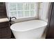 Bright bathroom showcasing a soaking tub with modern fixtures and a large window at 1850 Kirkmont Nw Dr, Marietta, GA 30064