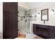 Bathroom with tiled shower and glass door, dark wood cabinets, and quartz countertops at 1850 Kirkmont Nw Dr, Marietta, GA 30064