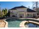 Back of house with large windows overlooks a stone trimmed kidney shaped pool with tanning spa at 1850 Kirkmont Nw Dr, Marietta, GA 30064