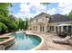 A refreshing pool with a spa, patio, and elegant home in a private backyard setting at 1850 Kirkmont Nw Dr, Marietta, GA 30064