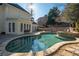 A kidney shaped pool with stone trim is accompanied by a tanning spa at 1850 Kirkmont Nw Dr, Marietta, GA 30064