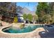 A kidney shaped pool with stone trim is accompanied by a tanning spa surrounded by lush landscaping at 1850 Kirkmont Nw Dr, Marietta, GA 30064