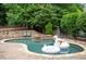 Beautiful pool with a stone waterfall feature, brick patio, and lush landscaping at 1850 Kirkmont Nw Dr, Marietta, GA 30064