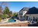 Back of house with large windows overlooks a stone trimmed kidney shaped pool with tanning spa at 1850 Kirkmont Nw Dr, Marietta, GA 30064