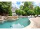 Inviting backyard pool area with jacuzzi, lounge chairs, mature trees, and a brick patio at 1850 Kirkmont Nw Dr, Marietta, GA 30064