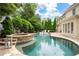 Stunning backyard with in-ground pool, spa, lush landscaping, and elegant patio area at 1850 Kirkmont Nw Dr, Marietta, GA 30064