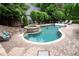 Lush backyard featuring a swimming pool with spa, brick patio, lounge chairs, and serene landscaping at 1850 Kirkmont Nw Dr, Marietta, GA 30064