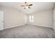 Large primary bedroom boasts vaulted ceiling, carpet, and natural light at 5474 Post Road Pass, Stone Mountain, GA 30088