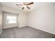 A bedroom featuring neutral walls, ceiling fan, carpet, and a bright window at 5474 Post Road Pass, Stone Mountain, GA 30088