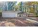 Charming single-story home with stone accents, a driveway, mature trees and a light green exterior at 5474 Post Road Pass, Stone Mountain, GA 30088