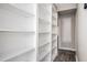 Hallway with dark vinyl floors and large white built-in shelves, providing ample storage space at 5474 Post Road Pass, Stone Mountain, GA 30088