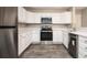 Well-lit kitchen featuring stainless steel appliances, stylish backsplash, and white cabinets and countertops at 5474 Post Road Pass, Stone Mountain, GA 30088
