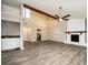 Open living room featuring a vaulted ceiling, ceiling fan, wet bar, and a stone fireplace at 5474 Post Road Pass, Stone Mountain, GA 30088