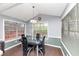 Bright dining room featuring a modern chandelier and a glass-top table with seating for four at 5705 Mountain Cres, Stone Mountain, GA 30087