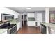 Well-lit kitchen boasting stainless steel appliances, white cabinets, and views to the living room at 5705 Mountain Cres, Stone Mountain, GA 30087