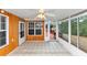 Cozy sunroom with wood paneled wall, tiled floors, ceiling fan and door leading to outdoor deck at 5705 Mountain Cres, Stone Mountain, GA 30087